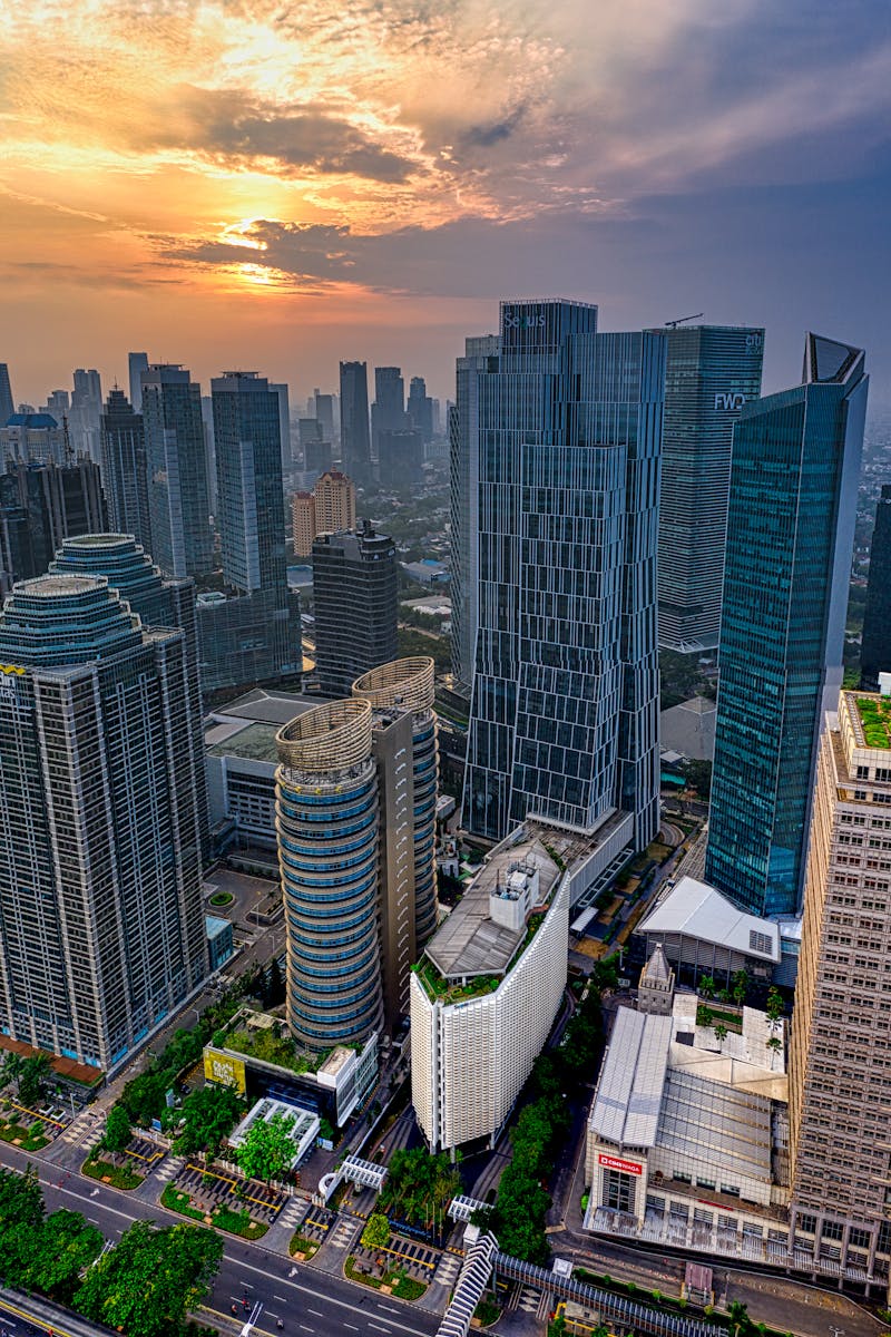 Dramatic sunset over Jakarta's skyline, highlighting its modern skyscrapers and urban landscape.