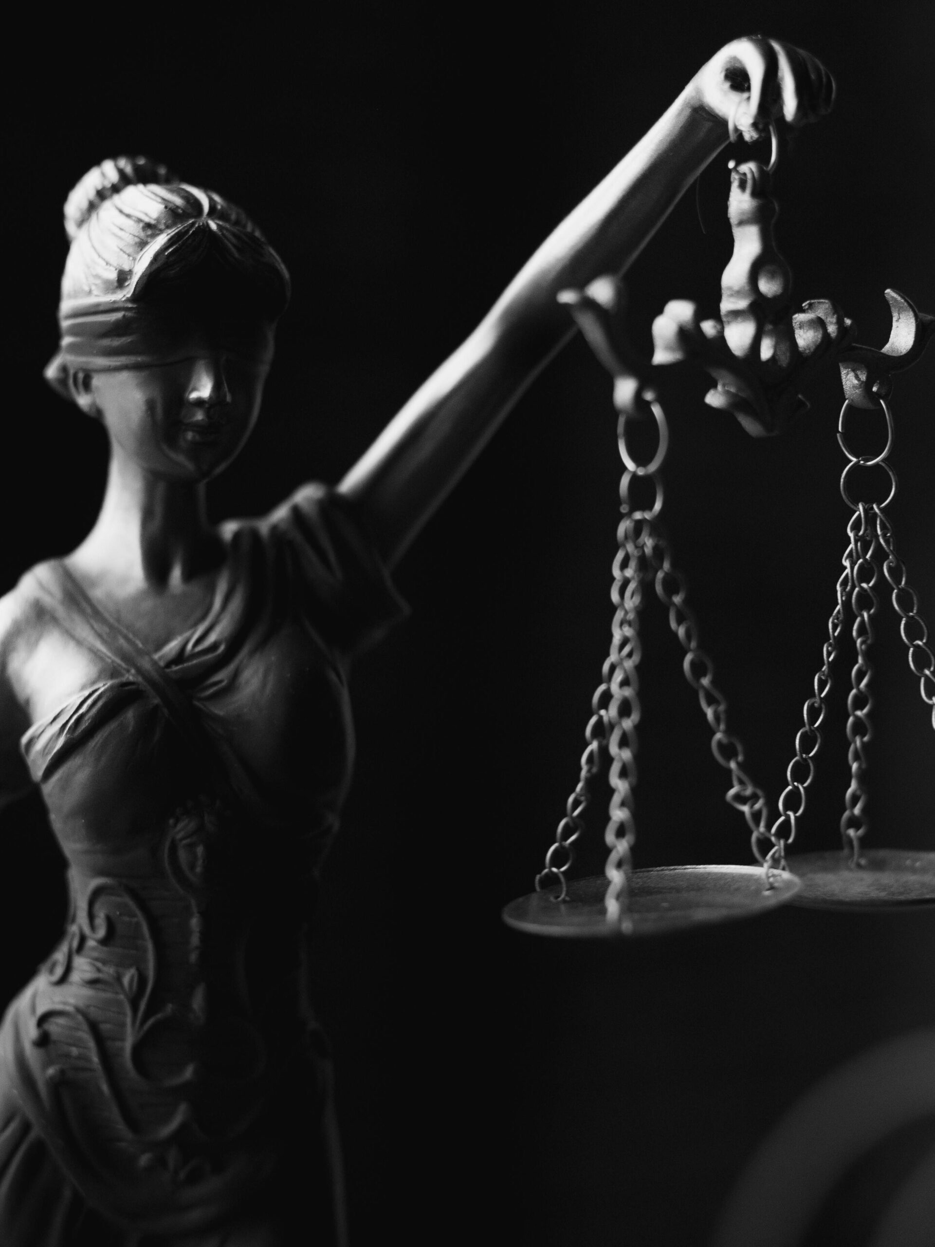 pexels-photo-6077181-6077181 A close-up black and white photo of the Lady Justice figurine with scales.